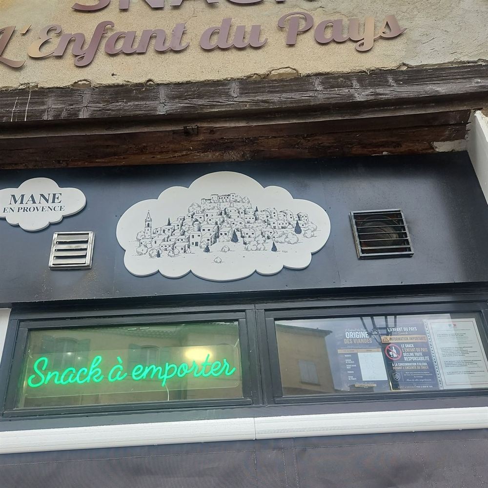 Enseigne du snack avec le village de Mane dessiné dans un nuage