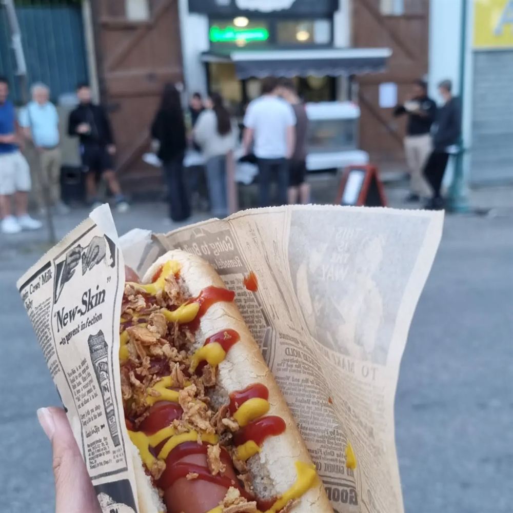 Hot-dog avec oignons frits, ketchup et moutarde dans du papier journal